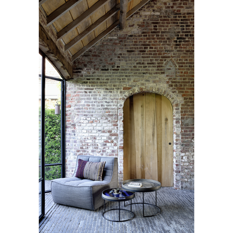 The Tray Coffee Table Set from Ethnicraft in an indoor courtyard.