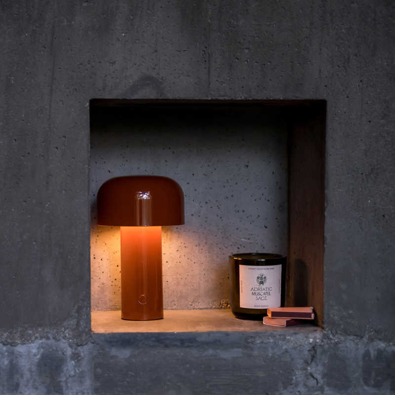 The Bellhop Portable Table Lamp from FLOS in a bedroom.