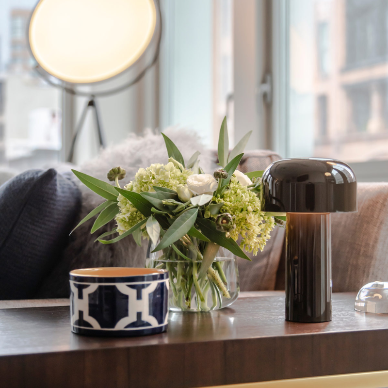 The Bellhop Portable Table Lamp from FLOS in a living room.