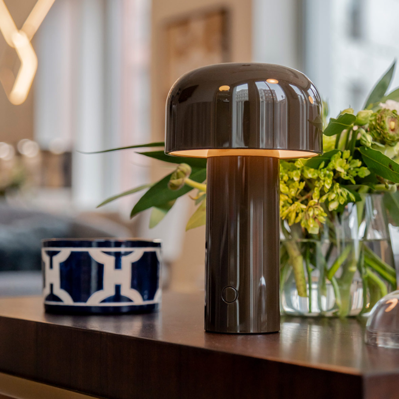 The Bellhop Portable Table Lamp from FLOS in a lounge.