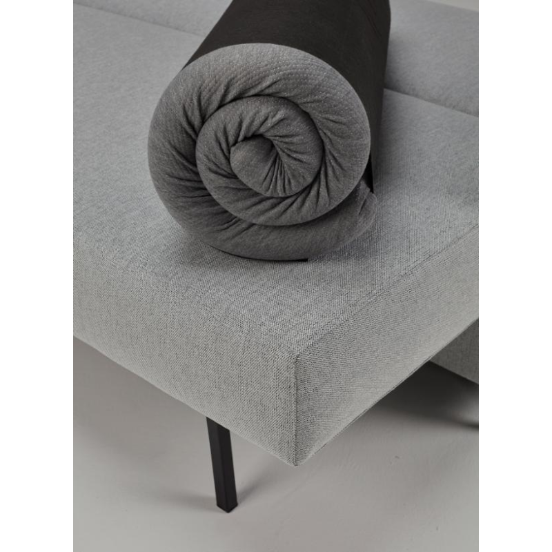 The Full Size Mattress Pillow Topper from Innovation Living rolled up on a sofa bed.