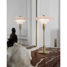 The PH 2/1 Pale Rose Brass Table Lamp from Louis Poulsen within a den.