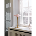 The PH 2/1 Pale Rose Brass Table Lamp from Louis Poulsen in a family area.