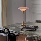 The PH 2/1 Pale Rose Brass Table Lamp from Louis Poulsen in a kitchen and dining setting.