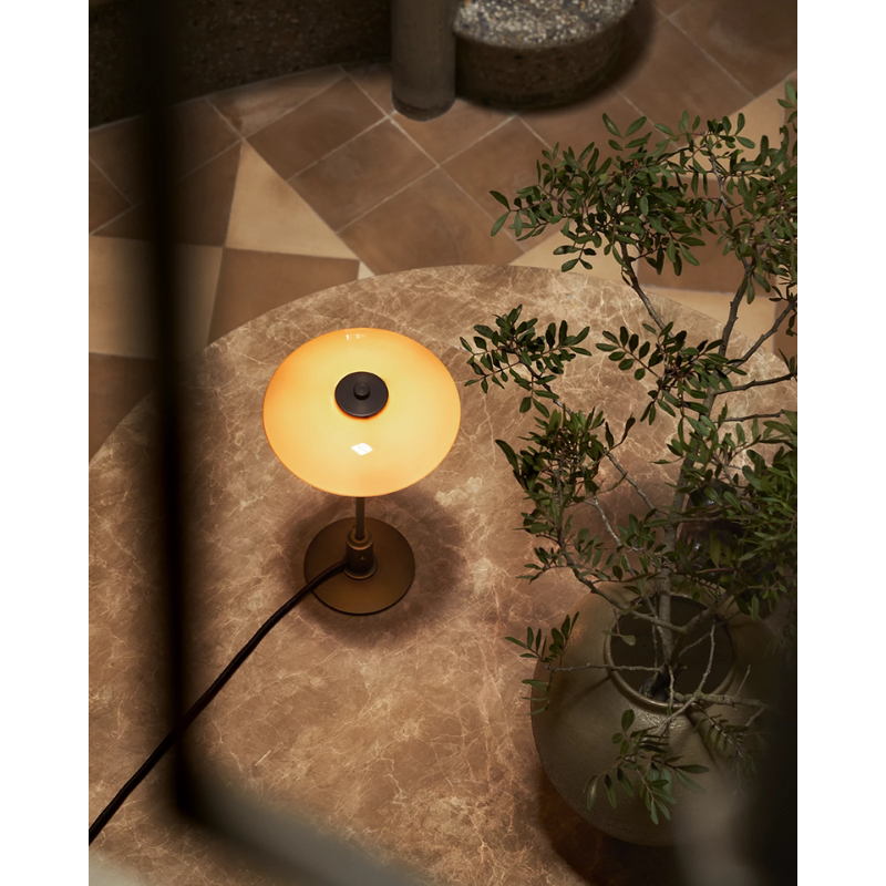 The PH 2/1 Dusty Terracotta Table Lamp from Louis Poulsen in a lounge.