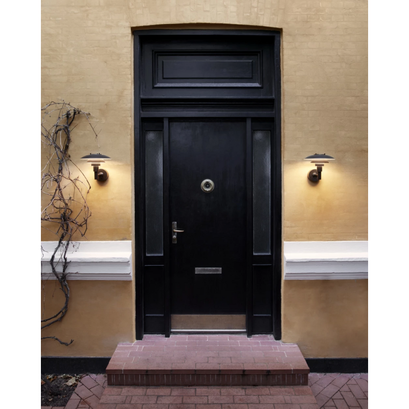 The PH 3-2½ Wall from Louis Poulsen outdoors illuminating a doorway.