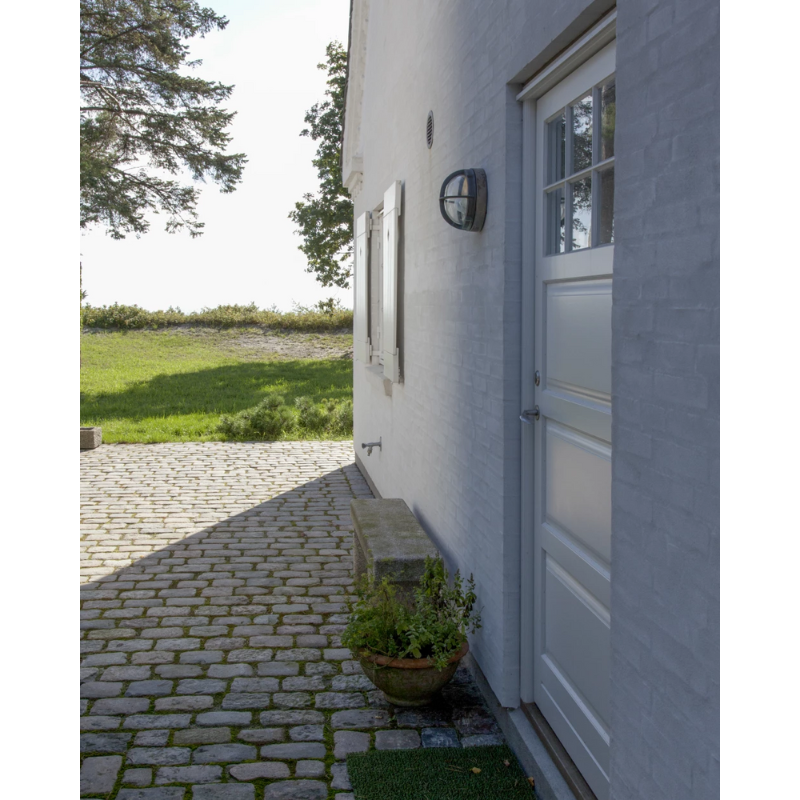 The Skot Wall from Louis Poulsen lighting up an outdoor doorway.