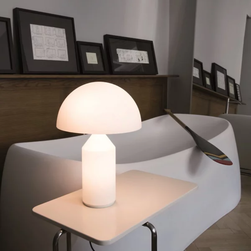 The Atollo Glass Table Lamp from Oluce in a living room.