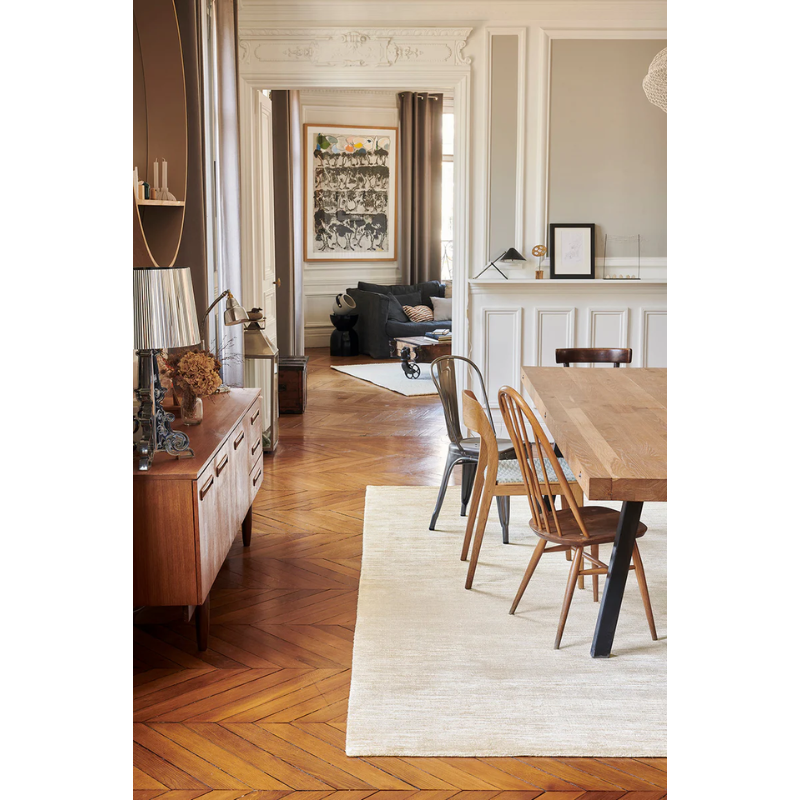 The Glam Banana Fiber Rug from Toulemonde Bochart in a dining room.