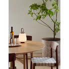 The Lucca Portable Lamp from &Tradition in a dining room.