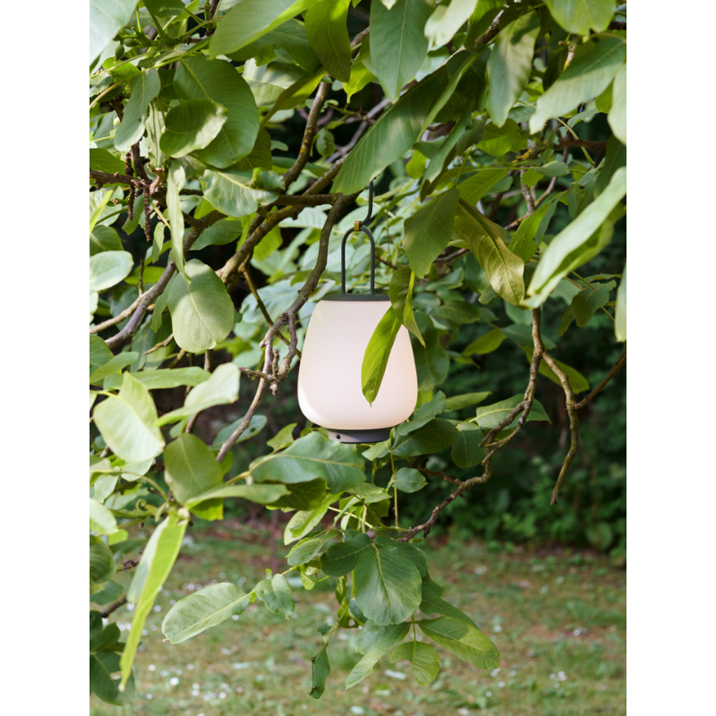 The Lucca Portable Lamp from &Tradition in a garden.