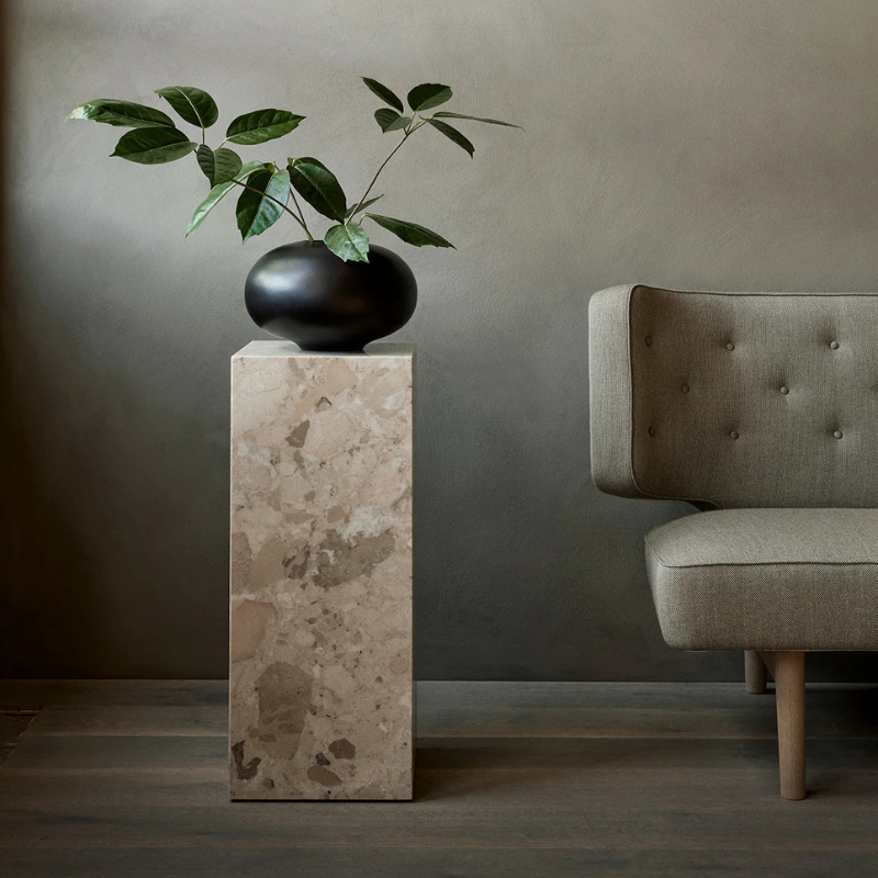 The Marble Plinth Pedestal from Audo Copenhagen in a living space.