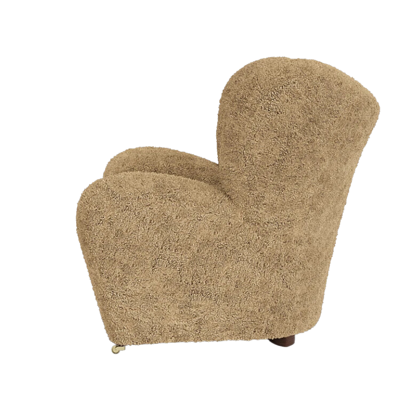 The Tired Man Sheepskin Lounge Chair from Audo Copenhagen in honey with dark stained oak legs from the side.