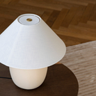 The 37 inch Torso Table Lamp by Audo Copenhagen brass dimmer touch switch detail on top of a side table.