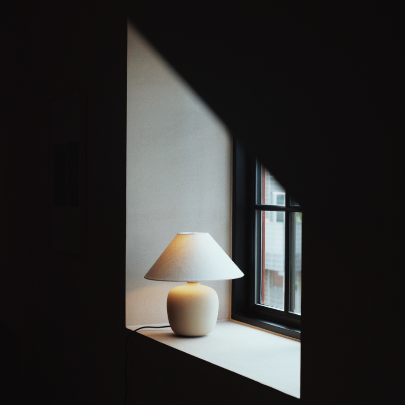 The 37 inch Torso Table Lamp by Audo Copenhagen on a windowsill.