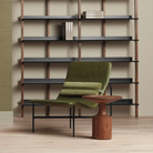 The Browser Tall Bookcase from Blu Dot with walnut uprights and oblivion shelving in a living room.