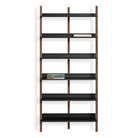 The Browser Tall Bookcase from Blu Dot with walnut uprights and oblivion shelving in a lifestyle.