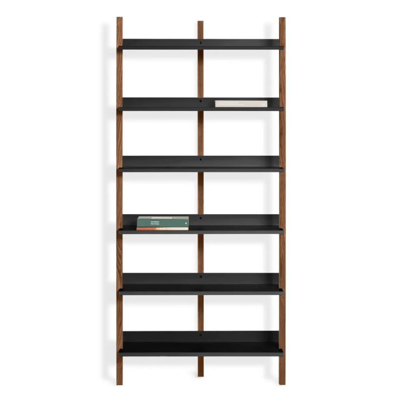 The Browser Tall Bookcase from Blu Dot with walnut uprights and oblivion shelving in a lifestyle.