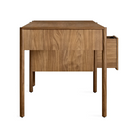 The Cursive Desk from Blu Dot in walnut from the side with an open drawer.