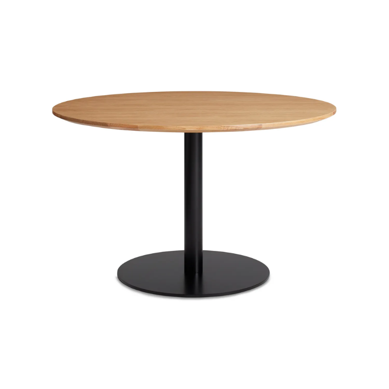 The 48 inch round Easy Dining Table from Blu Dot with a white oak top and black base from an angle.