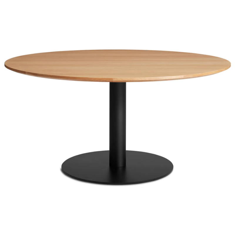 The 60 inch round Easy Dining Table from Blu Dot with a white oak top and black base from an angle.