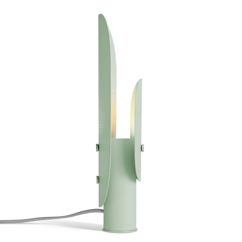 The Filter Table Lamp from Blu Dot in mint from the side turned on.