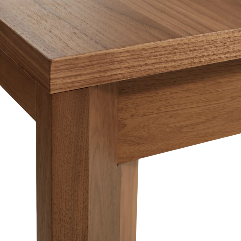 The 60 to 84 inch Moreover Extension Dining Table from Blu Dot in walnut corner.