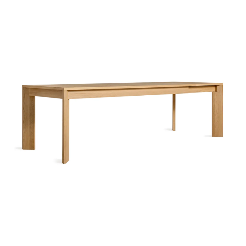 The 80 to 104 inch Moreover Extension Dining Table from Blu Dot in white oak extended from an angle.