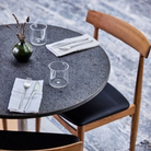 Eikund dining chair oak with black leather seat pad in restaurant