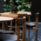 Eikund dining chair oak with black leather seat pad in restaurant 
