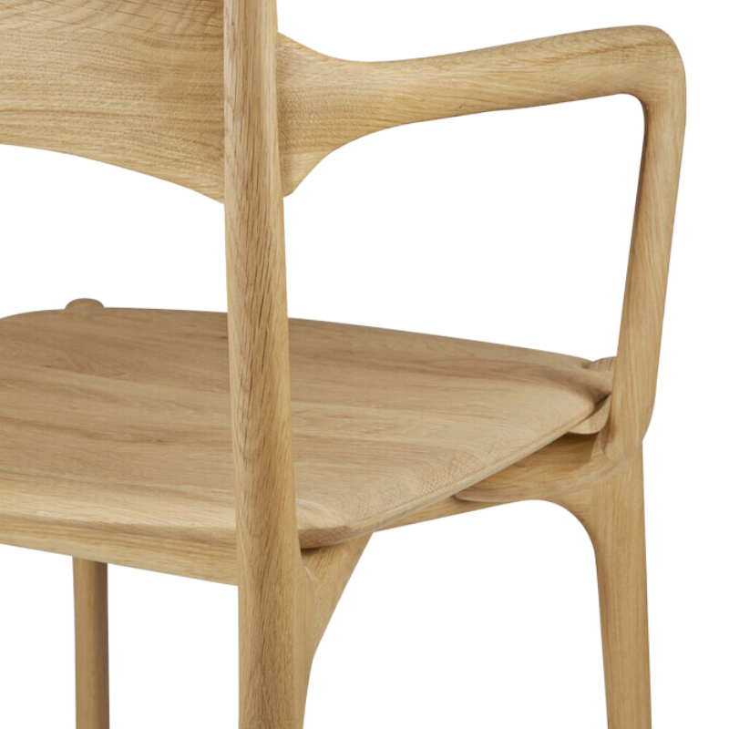 The PI Dining Chair from Ethnicraft with an armrest focusing on the seat.