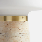 The Nova Table Lamp by Woud in ivory travertine in a detailed image of the opal shade and brass detailing.