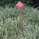 The Amelie Pro Garden Lamp from Zafferano outdoors in a garden.