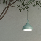 The Amelie Pro Hanging Lamp from Zafferano outdoors attached to a plant.