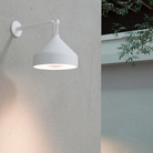 The Amelie Pro Wall Lamp from Zafferano outdoors in a garden.